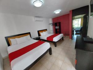 a hotel room with two beds and a television at Santa Maria del Cabo in San José del Cabo