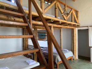a room with two bunk beds and a ladder at La Cabaña del Mar Vichayito in Vichayito