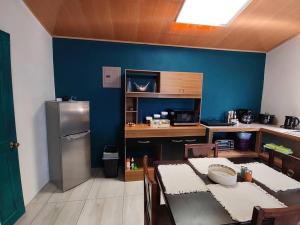 a kitchen with a table and a blue wall at Casa El Escondido in Monteverde Costa Rica