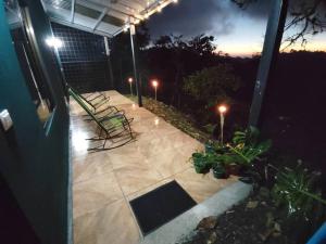 a patio at night with two chairs and lights at Casa El Escondido in Monteverde Costa Rica