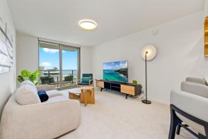 een woonkamer met een bank en een tv bij Sky Ala Moana 3305 condo in Honolulu