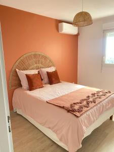 una camera da letto con un grande letto con pareti arancioni di Appartement Océan View a Le Robert