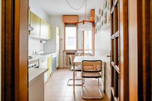 uma cozinha com uma mesa e cadeiras em Appartamento 400 mt Stazione Linea S1 Milano em San Giuliano Milanese