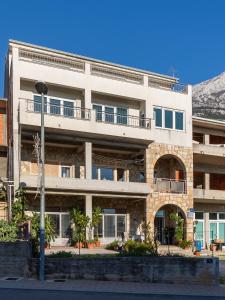 ein Apartmenthaus mit Balkon auf einer Straße in der Unterkunft Apartments with a parking space Makarska - 22017 in Makarska