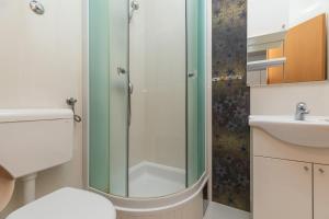 ein Bad mit einer Dusche, einem WC und einem Waschbecken in der Unterkunft Apartments with a parking space Makarska - 22017 in Makarska