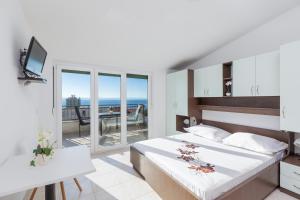 Schlafzimmer mit einem Bett und Meerblick in der Unterkunft Apartments with a parking space Makarska - 22017 in Makarska