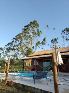 une maison avec une aire de jeux avec un banc et un parasol dans l'établissement Casa Sítio Campo e Mar Balneário Picarras, à Balneário Piçarras