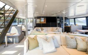 Cette chambre comprend un canapé et des oreillers sur un bateau. dans l'établissement Milford Sound Overnight Cruise - Fiordland Discovery, à Milford Sound