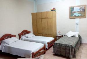 Zimmer mit 2 Einzelbetten und einem Schrank in der Unterkunft Alojamiento Turístico Pelucho Sillero in Junín