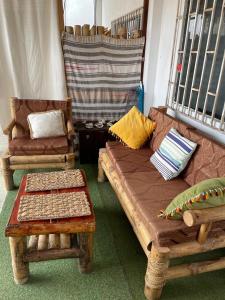 sala de estar con sofá y 2 sillas en Habitación en la playa en Tumbes