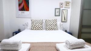 1 dormitorio con 1 cama blanca y 2 almohadas en Apartamento Ciudad Jardín con Tranquilidad y WiFi en Bilbao