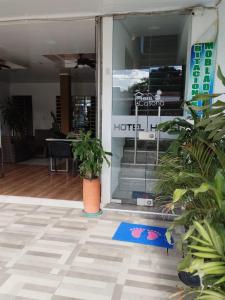 une porte d'entrée d'un hôtel avec des plantes devant lui dans l'établissement HOTEL LA CASONA, à Tauramena