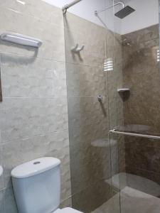 a bathroom with a glass shower with a toilet at HOTEL LA CASONA in Tauramena