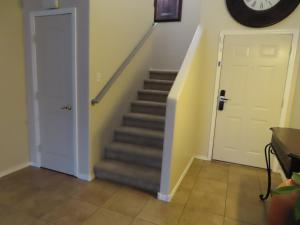 a staircase with a white door and a clock on the wall at Beautiful, spacious home in ABQ in Albuquerque
