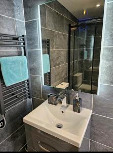 a bathroom with a white sink and a mirror at The Cute Cabin in Santon