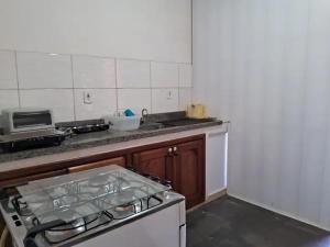 Apartamento em Ilhéus في ايليوس: مطبخ مع فرن علوي موقد في مطبخ