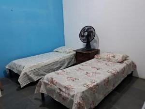 dwa łóżka siedzące obok siebie w pokoju w obiekcie Apartamento em Ilhéus w mieście Ilhéus