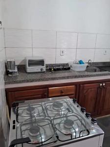 a stove top oven in a kitchen next to a counter at Apartamento em Ilhéus in Ilhéus