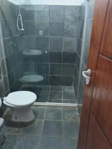 a bathroom with a toilet and a tiled floor at Apartamento em Ilhéus in Ilhéus