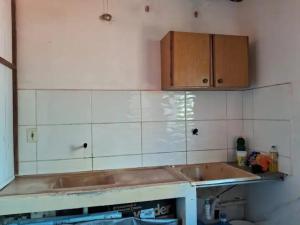 eine Küche mit einer Spüle und Holzschränken in der Unterkunft Apartamento em Ilhéus in Ilhéus