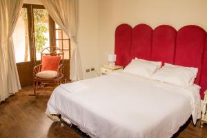 uma cama grande com uma cabeceira vermelha num quarto em Golden House guesthouse em Cochabamba