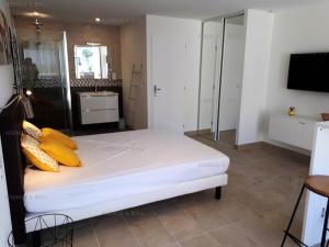 ein Schlafzimmer mit einem Bett mit gelben Kissen darauf in der Unterkunft Résidence Héliopolis Bâtiment D - Appartements pour 2 Personnes 584 - Naturiste in Cap d'Agde