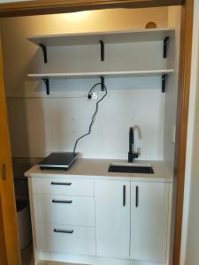 オークランドにあるPerfect living in Easternの白いキャビネットとシンクのあるキッチン