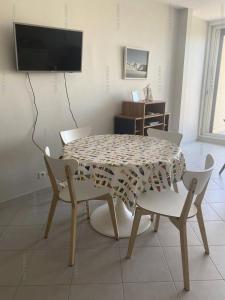 stół i krzesła w salonie z telewizorem w obiekcie Résidence Héliopolis Bâtiment E - STUDIO 2 pers. HELIOPOLIS Bâtiment E MAE-5494 w Cap d'Agde +1 zdjęcie