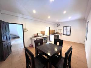 a dining room with a table and chairs and a kitchen at Mary’s Home Stay in Luang Prabang