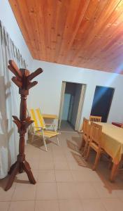Cette chambre dispose d'une table, de chaises et d'un plafond en bois. dans l'établissement Casa Santa Clara, à Santa Clara del Mar