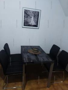 een eettafel met stoelen en een foto aan de muur bij Résidence Héliovillage - Maisons & Villas pour 4 Personnes 944 - Naturiste in Cap d'Agde