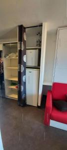 Pokój z czerwoną kanapą i lodówką w obiekcie Résidence Port Venus - Studio 2 pers. - Port Vénus MAE-4334 w Cap d'Agde