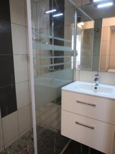 een badkamer met een wastafel, een spiegel en een bad bij Résidence Héliovillage - Maisons & Villas pour 4 Personnes 804 - Naturiste in Cap d'Agde