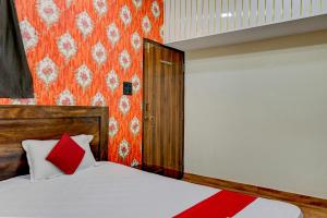 a bedroom with a bed with a red pillow at OYO Flagship Hotel RVR in Bilāspur