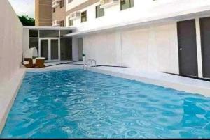 a swimming pool in front of a building at Kristinas Homestay- Cozy Resort Vibe Condotel in Cebu City
