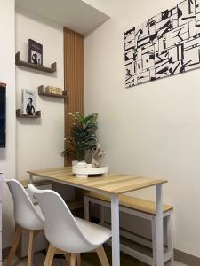 a dining room with a wooden table and white chairs at Kristinas Homestay- Cozy Resort Vibe Condotel in Cebu City +8 photos