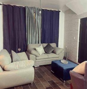sala de estar con 2 sofás y reposapiés azul en Lovely and warming 3 bed en Morelia