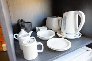 ein Küchenregal mit weißen Geräten drauf in der Unterkunft The Club Hotel in Gladstone