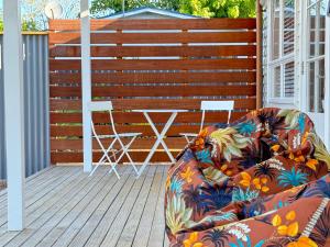 a couch sitting on a deck next to a wooden fence at Miami one one in Oneroa