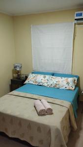 een slaapkamer met een bed met twee handdoeken erop bij Brisas Iguazú in Puerto Iguazú