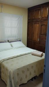 een slaapkamer met 2 bedden en een houten kast bij Brisas Iguazú in Puerto Iguazú