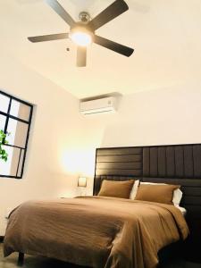 a bedroom with a bed with a ceiling fan at Leveli Coliving in Guadalajara +73 photos