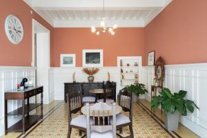 a dining room with orange walls and a table and chairs at Casa Cáceres in Lima