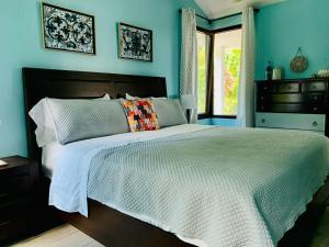 a bedroom with a large bed with blue walls at Enjoy Mountain Retreat Close to Panama Beaches in Chame