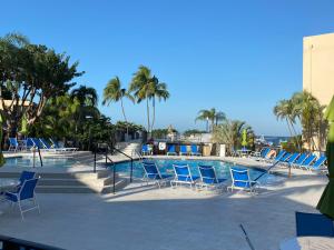 a swimming pool with blue chairs and palm trees at Moon Bay Condo, Paradise Found in Sunny Key Largo, Florida in Key Largo