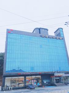 a large glass building with a sign on top of it at Freshia Hotel in Incheon