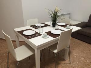 una mesa blanca con sillas y platos blancos. en Apartamento Centro Historico Teruel, en Teruel