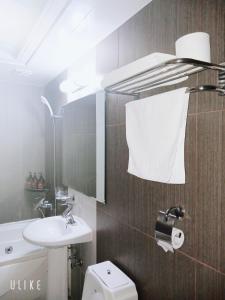 a bathroom with a sink and a toilet and a mirror at Freshia Hotel in Incheon