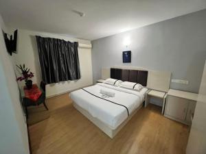 a bedroom with a large white bed and a chair at Seeds Hotel Cheras Maluri in Kuala Lumpur