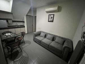 een woonkamer met een bank en een tafel bij Seeds Hotel Cheras Maluri in Kuala Lumpur